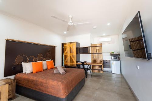 a bedroom with a large bed and a kitchen at Safari Lodge Motel in Tennant Creek
