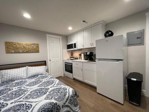 a small kitchen with a bed and a white refrigerator at Brand New Guest Suite + Full Kitchen + Parking in San Jose