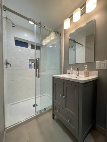 a bathroom with a sink and a shower with a glass door at Brand New Guest Suite + Full Kitchen + Parking in San Jose