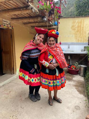 two women in traditional dress posing for a picture at Munay Kausay in Urubamba