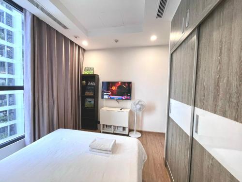 a bedroom with a white bed and a tv at Great 2bedroom Apt Quick To My Dinh And Marriott Hotel, 30 Minutes To Airport in Hanoi