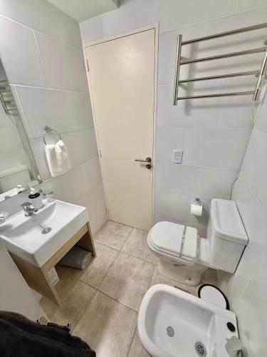 a white bathroom with a sink and a toilet at Petit Premium Nueva Cba - Oulton in Córdoba