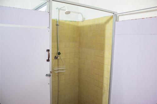 a bathroom with a shower with a yellow tile at Hostal Los Milagros in Santa Ana