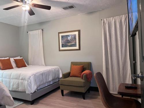1 dormitorio con 1 cama, 1 silla y ventilador de techo en Spacious, Quiet, Near Zoo, Stadium & Family Spots, en Atlanta