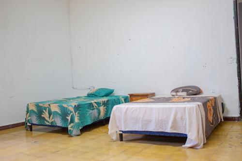 a room with two beds and a table in it at Hostal Los Milagros in Santa Ana