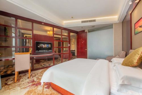 a hotel room with a bed and a tv at Billions-Earn Hotel (near Guangdong Foshan Creative Park and China Ceramics City) in Foshan