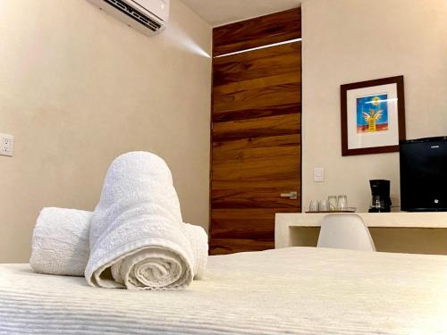 a bedroom with a bed with towels on it at Cocuna Boutique Suites La Manzanilla Jalisco in La Manzanilla