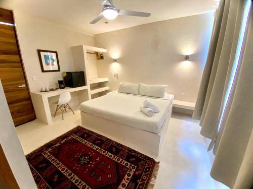 a bedroom with a white bed and a red rug at Cocuna Boutique Suites La Manzanilla Jalisco in La Manzanilla