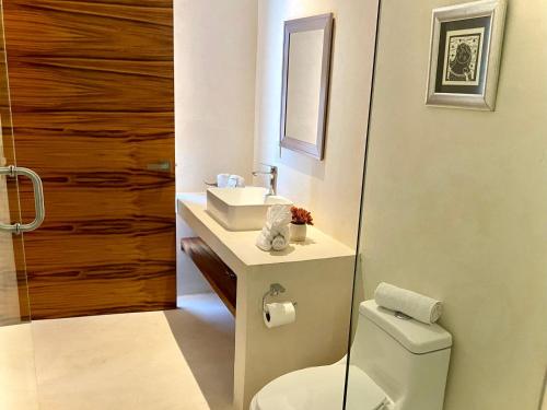 a bathroom with a toilet and a sink at Cocuna Boutique Suites La Manzanilla Jalisco in La Manzanilla