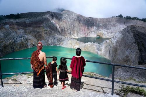 a family standing at the edge of a cliff overlooking a lake at New Daniel Lodge & Travel in Ende