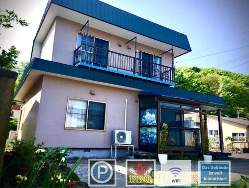 a house with a balcony on top of it at kitagunihouse noboribetsu in Noboribetsu