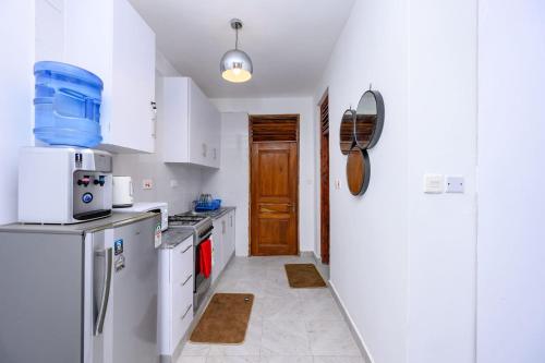 a kitchen with white cabinets and a refrigerator at Casa Johanne Malindi staycation in Malindi