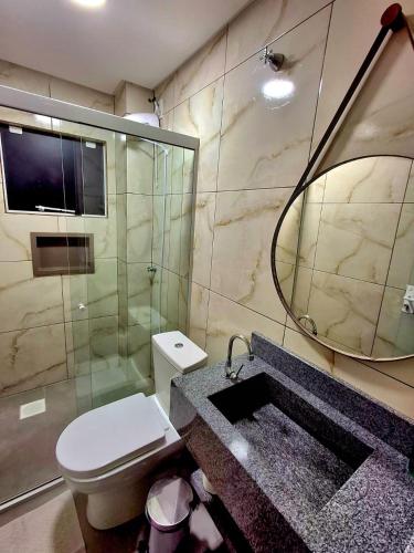 a bathroom with a toilet and a sink and a mirror at Apartamento novo - 2 Quartos Casal até 4 pessoas - Centro - Santa Rosa - RS in Santa Rosa