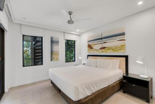 una camera da letto con un letto e due finestre di Temple Resort & Spa Port Douglas a Port Douglas