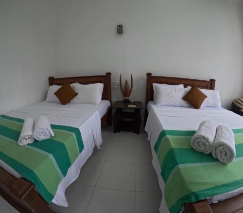 two beds sitting next to each other in a room at Villa Rivora in Kitulgala