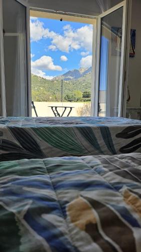 un lit devant une fenêtre avec vue dans l'établissement Villa Noel, à Calenzana