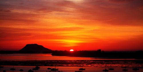 a sunset over a body of water with boats at Coppelia Sunrise in Omokoroa