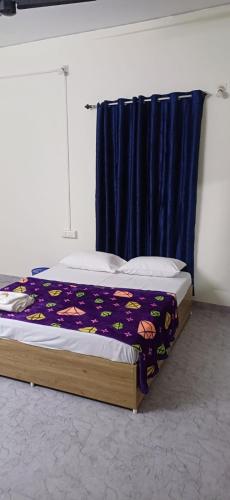 a bedroom with a bed with a blue curtain at Sivahari Homestay in Trivandrum