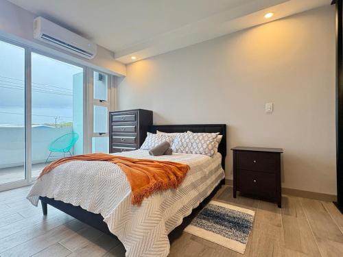 a bedroom with a bed with a dresser and a window at Premium Apartment In Be Cariari in Heredia