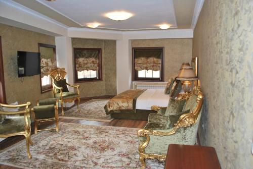 1 dormitorio con 1 cama, escritorio y sillas en Hotel Vila Sigal Korce, en Korçë