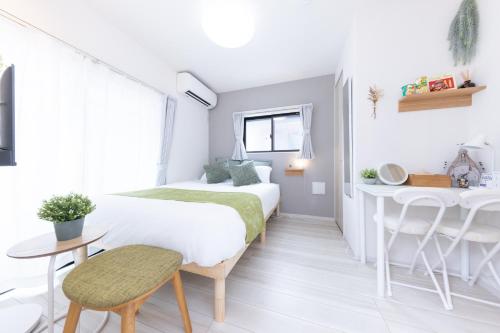 a bedroom with two beds and a desk at メルディア東堀切 in Tokyo