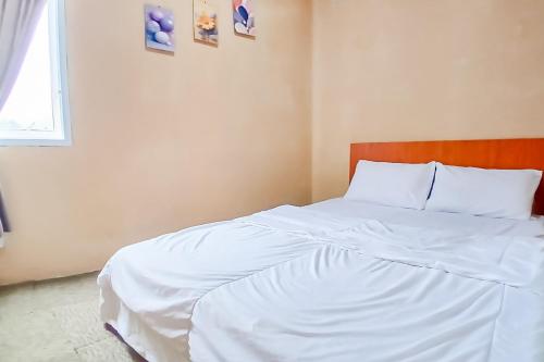 a white bed in a bedroom with a window at Danin Villa Syariah Dieng Mitra RedDoorz in Dieng
