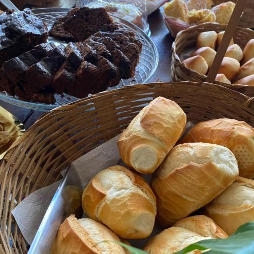 a bunch of loaves of bread in baskets on a table at Grand Maré Hotel in Peruíbe