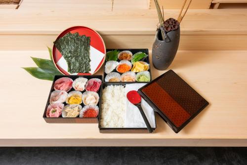 Una mesa cubierta con cajas de sushi y un libro. en ENT TERRACE GINZA Premium, en Tokio