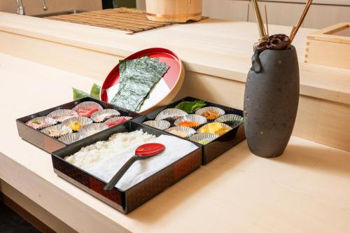 a tray of sushi on a counter next to a vase at ENT TERRACE GINZA Premium in Tokyo