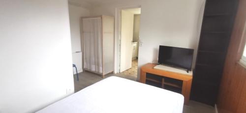 Una habitación con una cama y un televisor sobre una mesa. en Cottage studio, en Tregueux