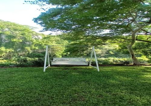 a swing sitting in a field in a park at Supalai Pasak Resort Hotel And Spa in Kaeng Khoi