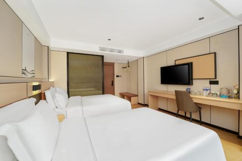 a hotel room with two beds and a television at Shanghai Tianhua Hotel in Shanghai