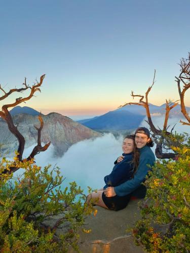 two women sitting on the edge of a mountain overlooking a lake at Nio Homestay and Tour in Licin
