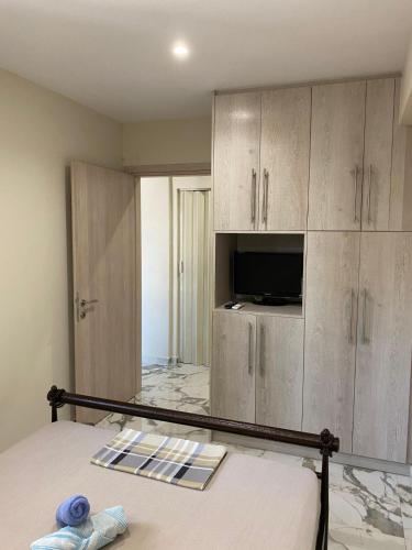 a bedroom with a bed with a television and cabinets at Chalkida Hilltop Apartments in Chalkida