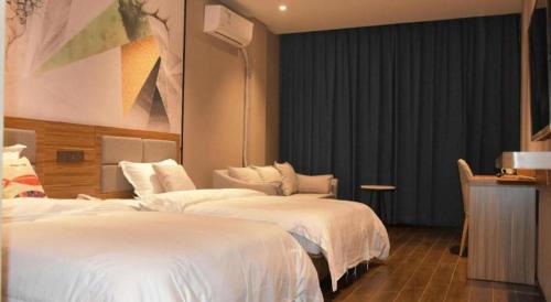 a hotel room with two beds and a desk at Shell Hotel Kaifeng Jin'an Road Bianxihu Wanda Plaza in Kaifeng