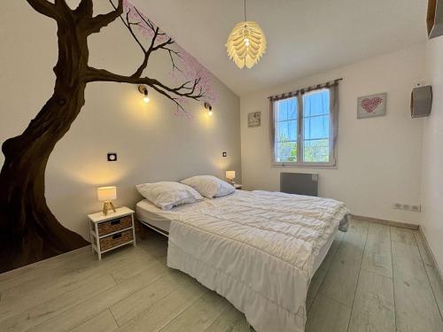 a bedroom with a large bed and a tree on the wall at Maison à Saint Denis d'Oléron - Jardin - 6 personnes - FR-1-246A-372 in Saint-Denis-dʼOléron