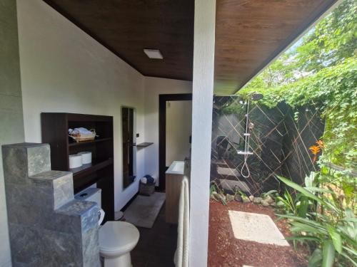 a bathroom with a toilet and a fence at Pantala Villa in Fortuna