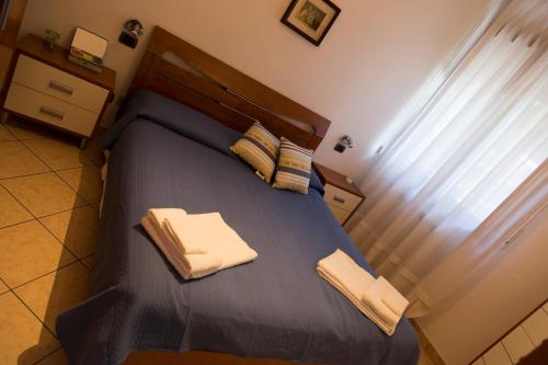 a bedroom with a blue bed with two pillows at Albergo Felice in Sottomarina