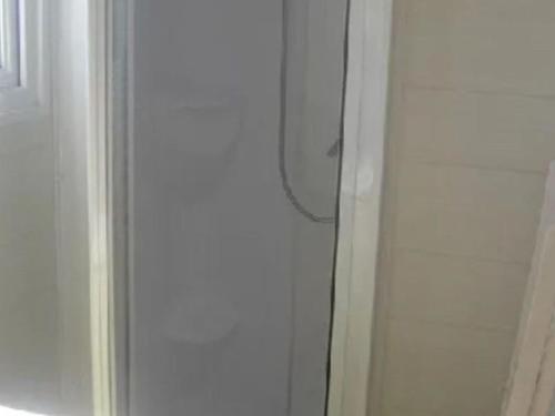 a shower with a glass door next to a toilet at Mobil home confortable avec terrasse en Charente-Maritime - API-1-52-690 in Le Fouilloux