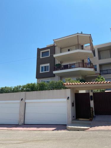a house with a white garage door and a building at Chalkida Hilltop Apartments in Chalkida