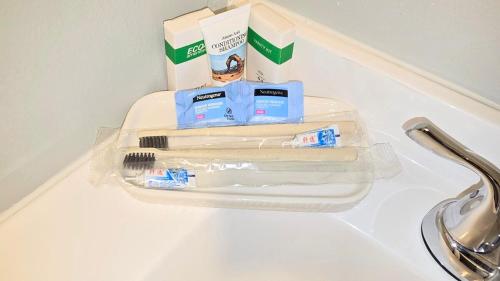 a bathroom counter with toothbrushes and a box on it at Irie Villa GameRoom Kids&PetFriendly CharcoalGrill in Fayetteville