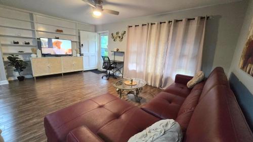 a living room with a couch and a television at Irie Villa GameRoom Kids&PetFriendly CharcoalGrill in Fayetteville