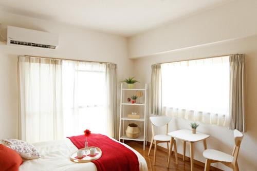 a bedroom with a bed and a table and chairs at G62 駅徒歩3分 おしゃれで可愛い 4人可能 3 minutes walk from the station Nagoya駅から1駅 in Nagoya