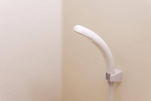 a white shower handle on a white wall at G62 駅徒歩3分 おしゃれで可愛い 4人可能 3 minutes walk from the station Nagoya駅から1駅 in Nagoya