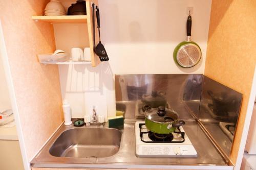 a small kitchen with a sink and a pot on a stove at G62 駅徒歩3分 おしゃれで可愛い 4人可能 3 minutes walk from the station Nagoya駅から1駅 in Nagoya