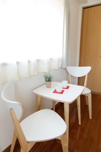 a table and two chairs and a white table and chairs at G62 駅徒歩3分 おしゃれで可愛い 4人可能 3 minutes walk from the station Nagoya駅から1駅 in Nagoya