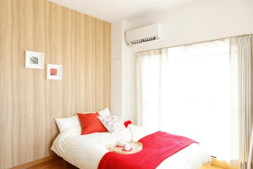 a bedroom with a bed with a table on it at G62 駅徒歩3分 おしゃれで可愛い 4人可能 3 minutes walk from the station Nagoya駅から1駅 in Nagoya