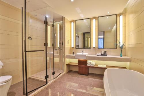 a bathroom with a shower and a toilet and a sink at SSAW Boutique Hotel Qidong Tiansheng in Qidong
