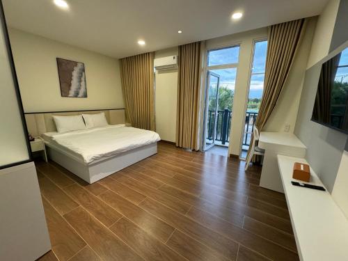 a hotel room with a bed and a balcony at Kacy Homestay, Wonderland Hồ Tràm miễn phí vé MUSEUM in Xuyên Mộc