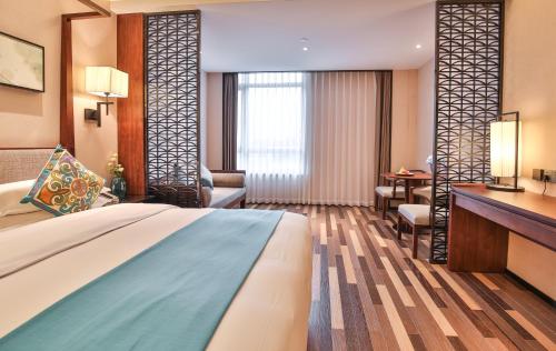 a hotel room with a bed and a desk at SSAW Boutique Hotel Qidong Tiansheng in Qidong